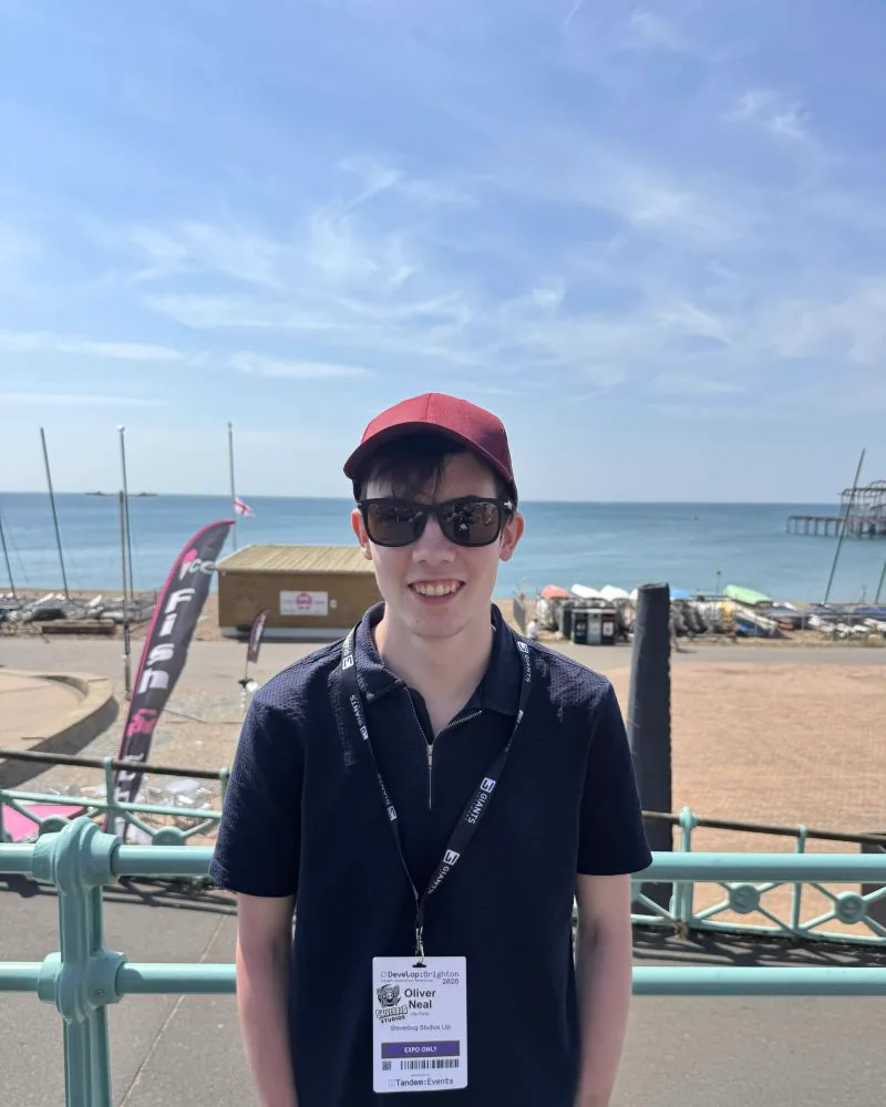 Oliver Neal wearing a Develop:Brighton attendee badge on Brighton seafront
